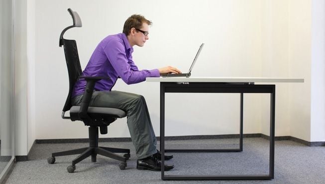 Man sitting with poor posture 